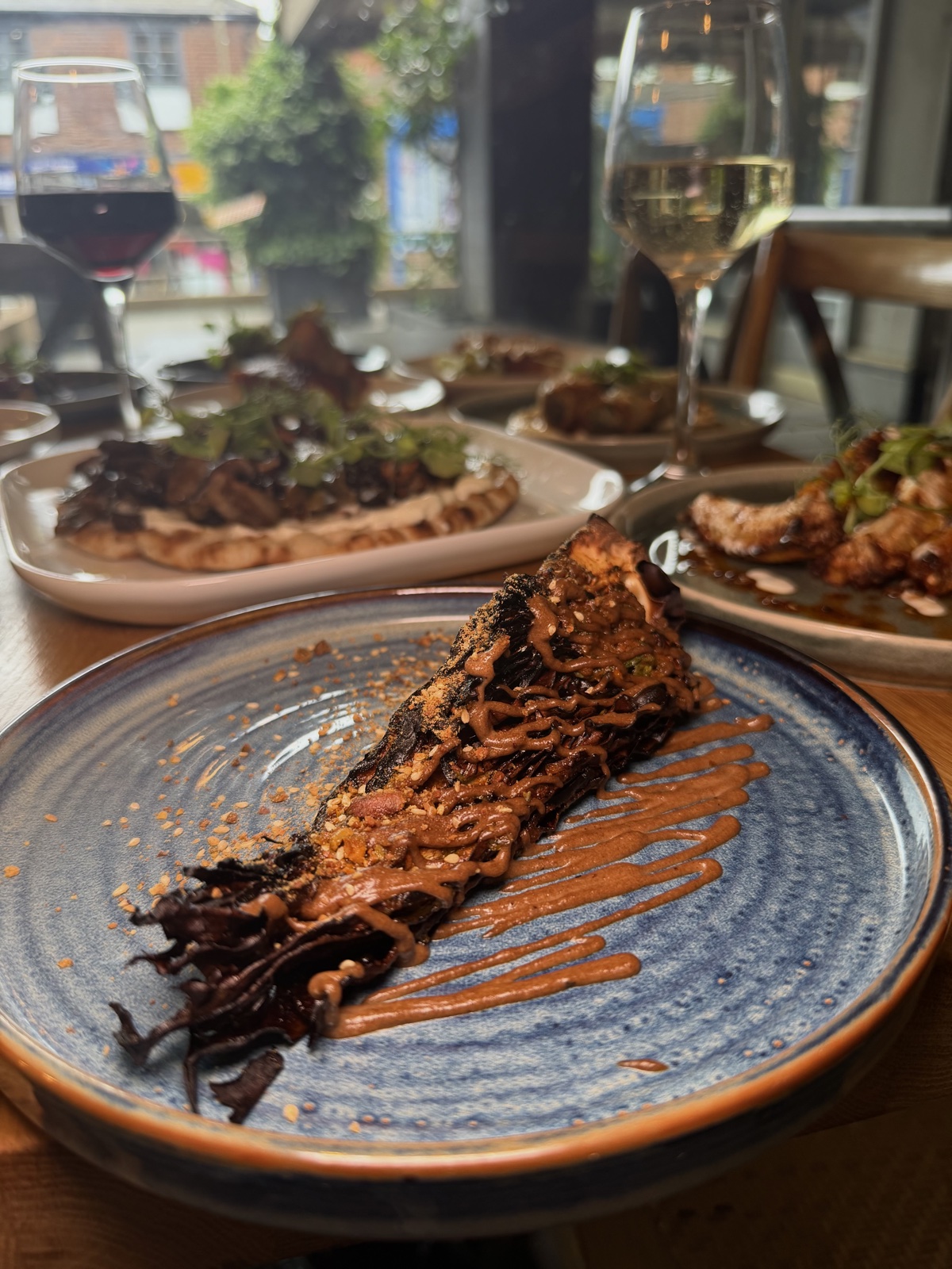 Charred radicchio and mushroom flatbread with white wine at lunch